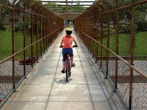 Person riding a bike over a bridge